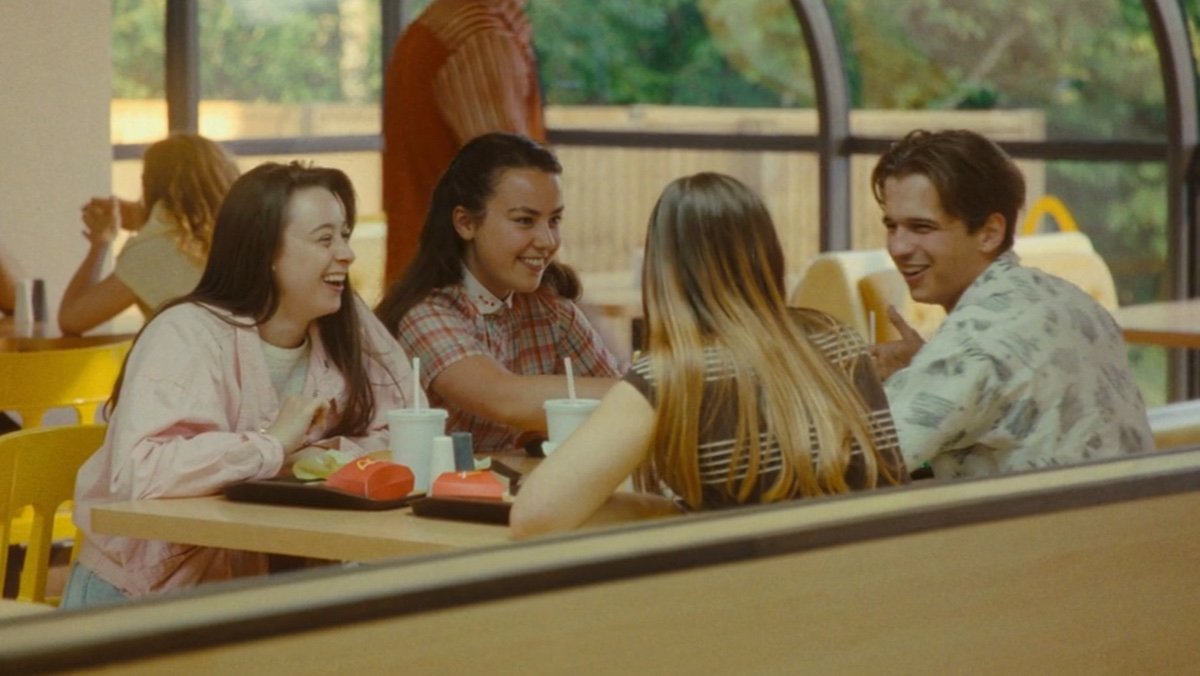 People laughing and eating at a McDonald's table in 1982 on Loki