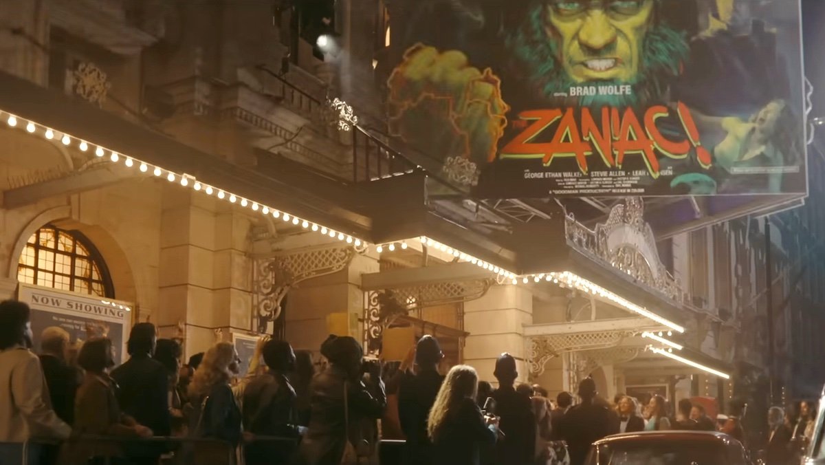 Mob of people entering a a theater under a marquee for a movie called Zaniac with a green hairy monster on Loki