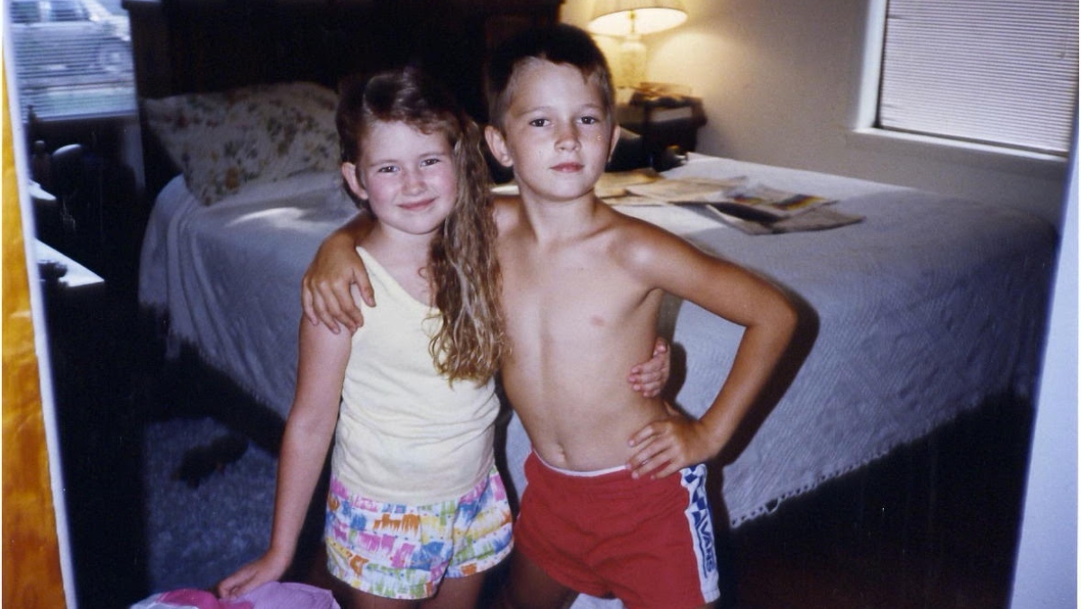 a photo of a young girl and boy in a bedroom with their arms around each other in the late 80s